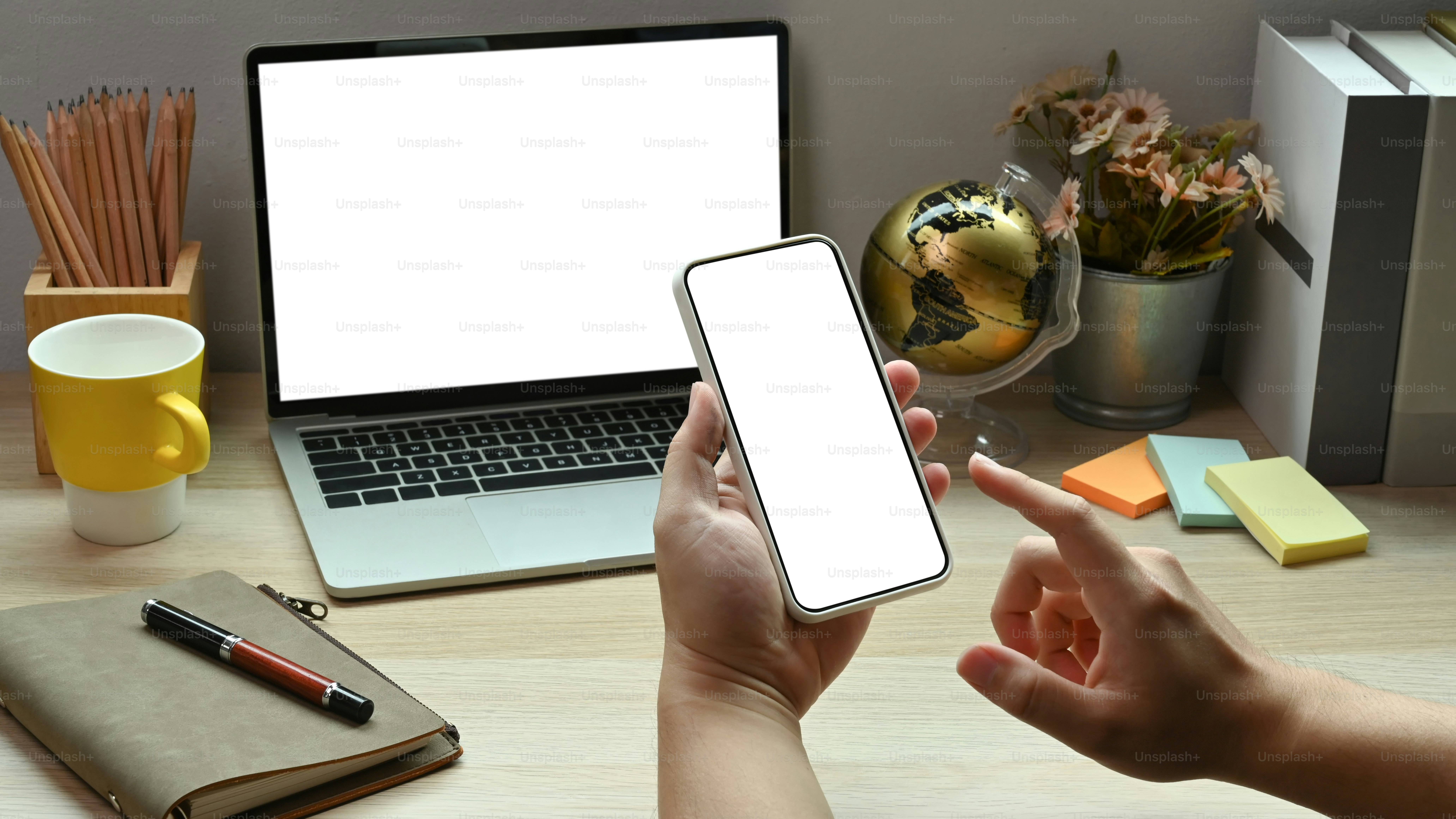 Close up view businessman using smart phone while siting at his workplace.