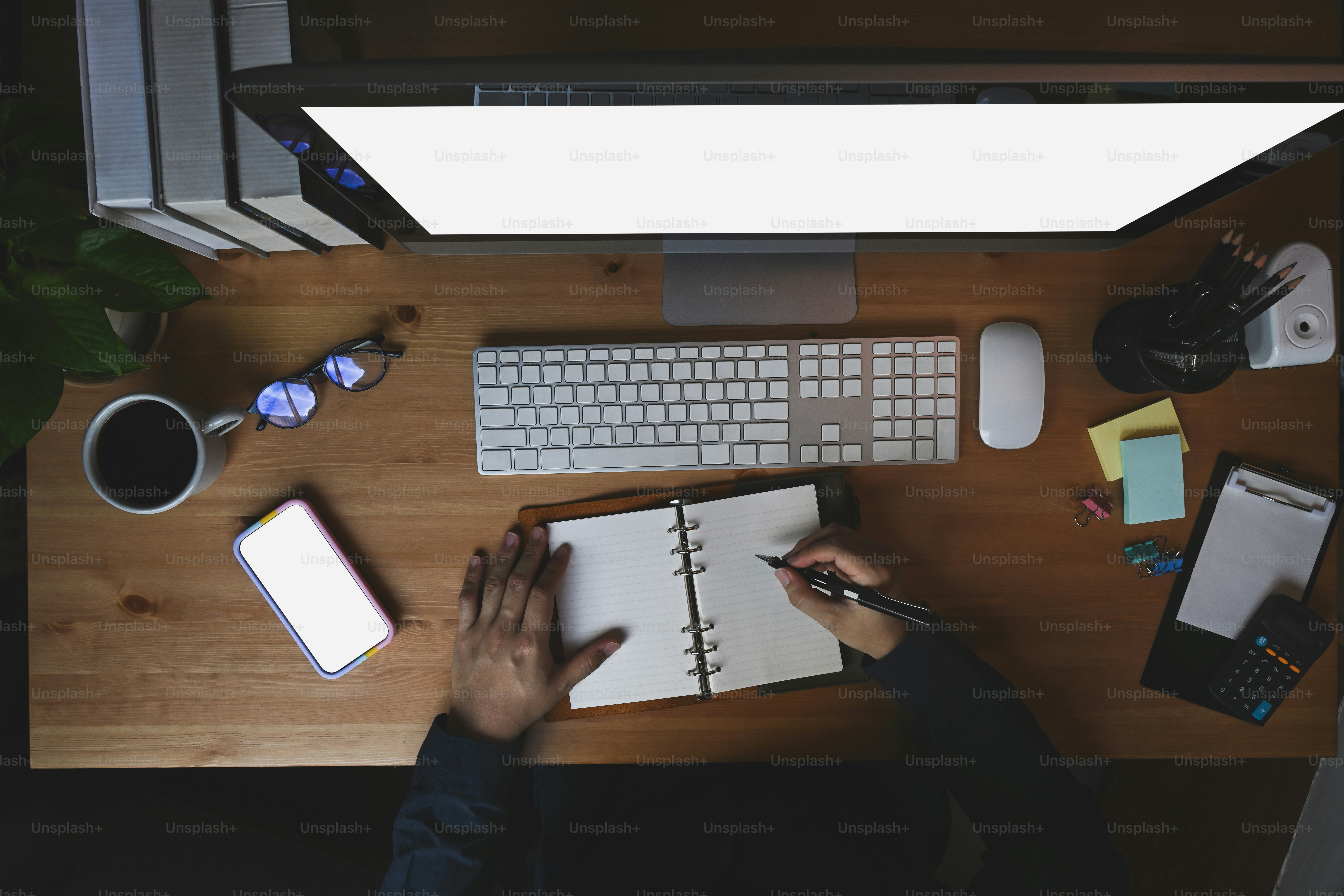 Person making notes and planning next steps while working at a computer
