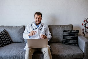 Médico latino consultor en línea y trabajando con computadora en casa en la ciudad de México