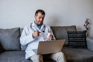 latin doctor man consulting online and working with computer at home in Mexico city