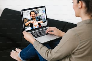 Vue arrière d’une femme latine d’affaires parlant à ses collègues mexicains dans une équipe d’affaires de vidéoconférence utilisant un ordinateur portable pour une réunion en ligne par appel vidéo travaillant à domicile en Amérique latine