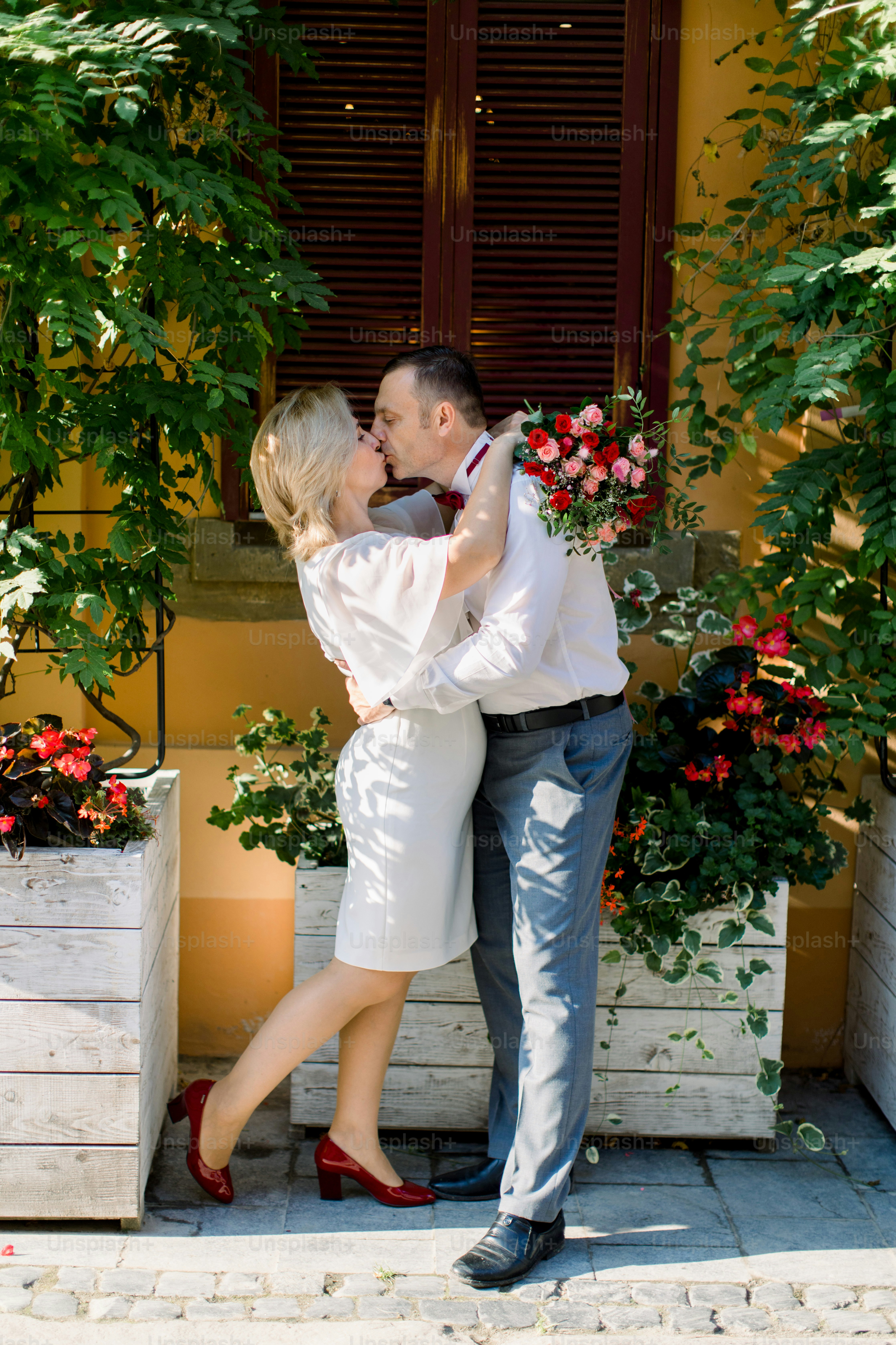 Hermosa pareja madura encantadora besándose, hombre y mujer con ropa  elegante, de pie cara a cara, abrazándose y disfrutando de su paseo por la  hermosa ciudad vieja foto – Imagen de Flores, image size:3000x4500