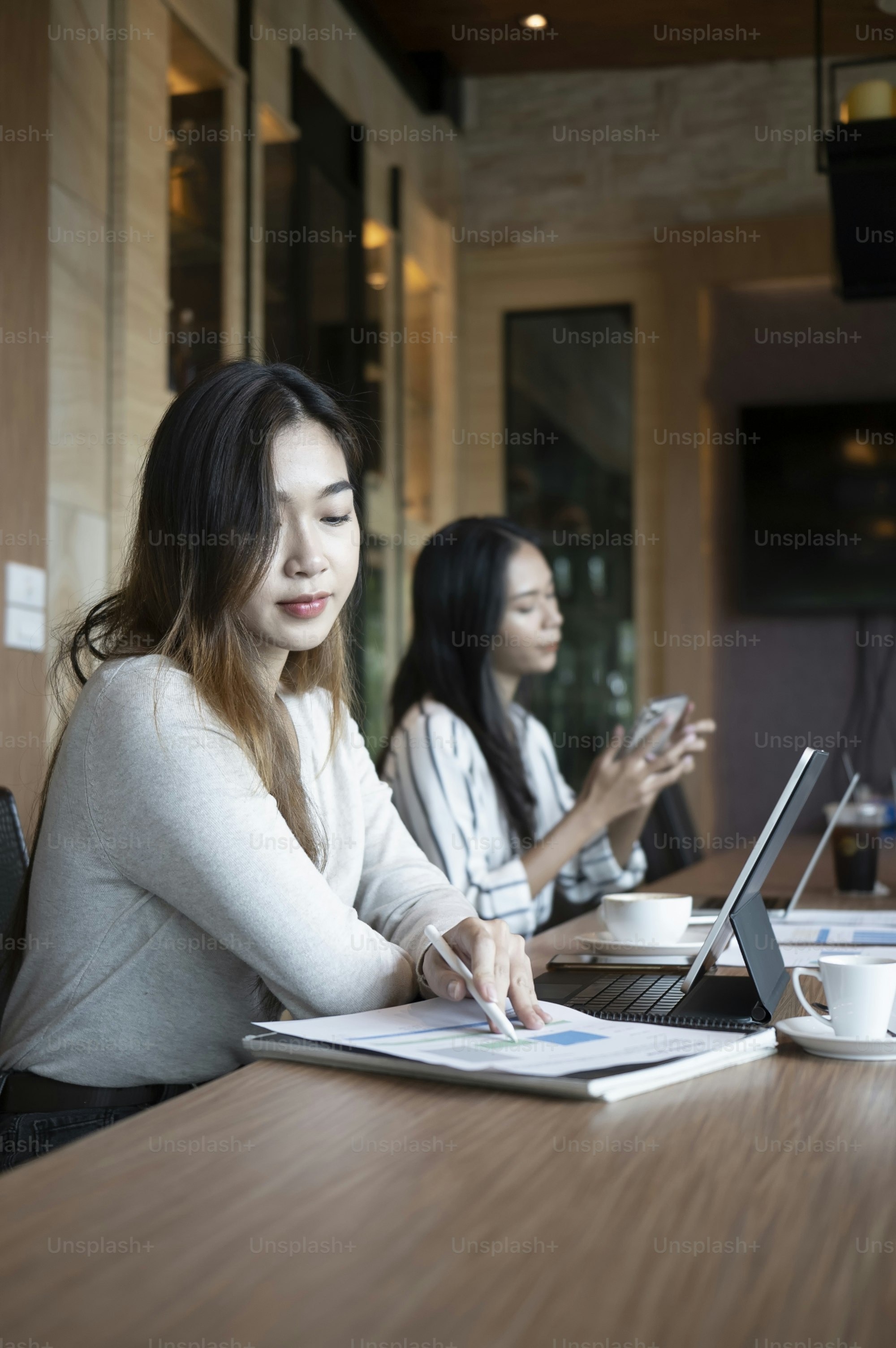 Zwei junge Frauen arbeiten zusammen in einem modernen Büro.