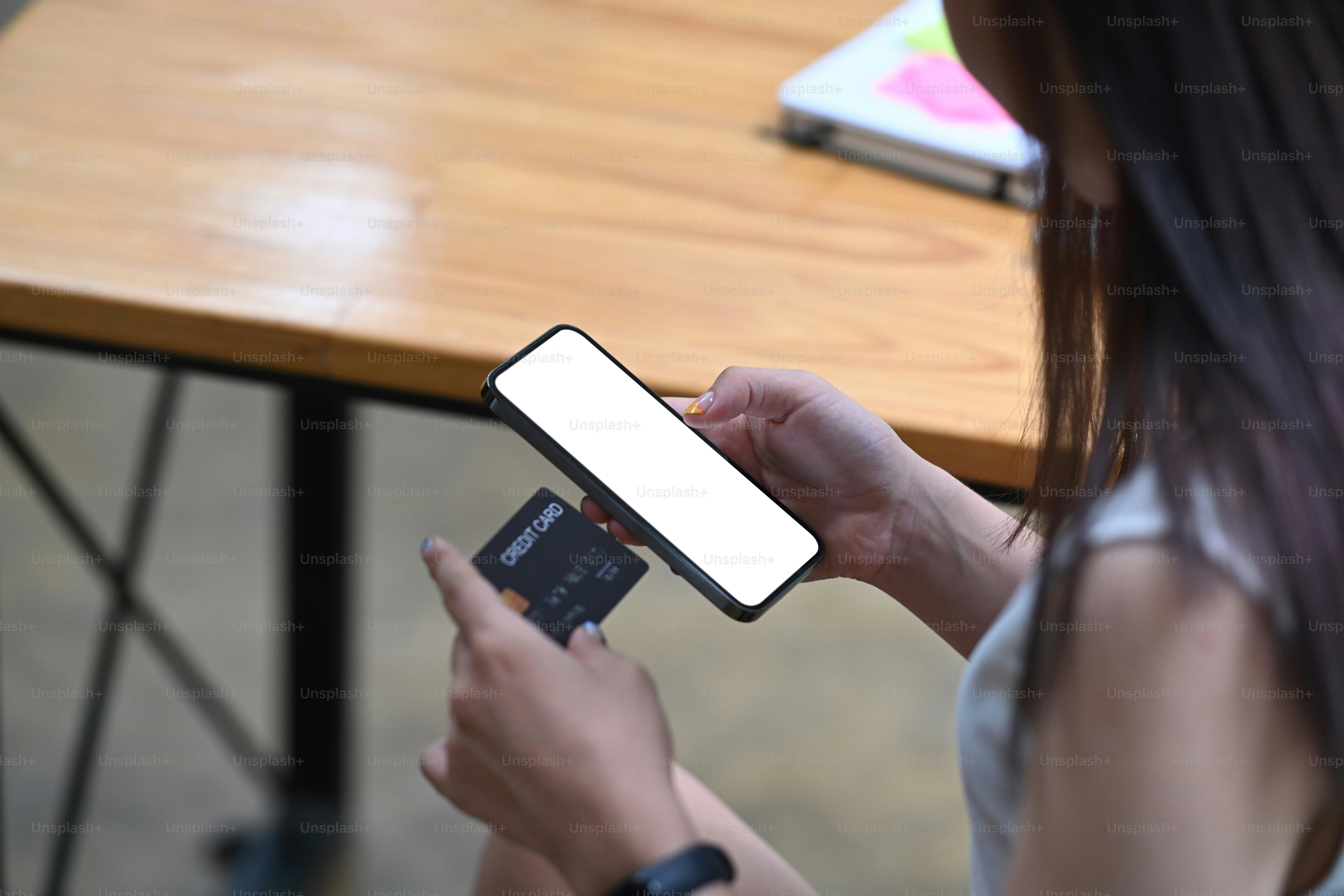 Young female holding smart phone and credit card for banking online or payment online.