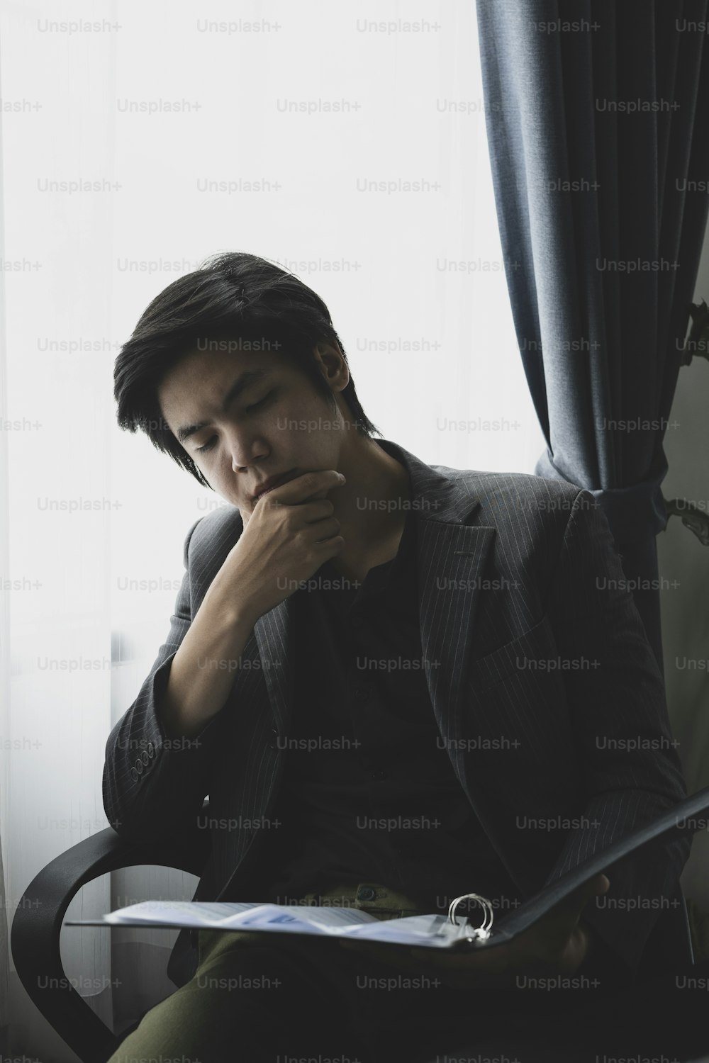 Serious businessman reading financial document at his office room.