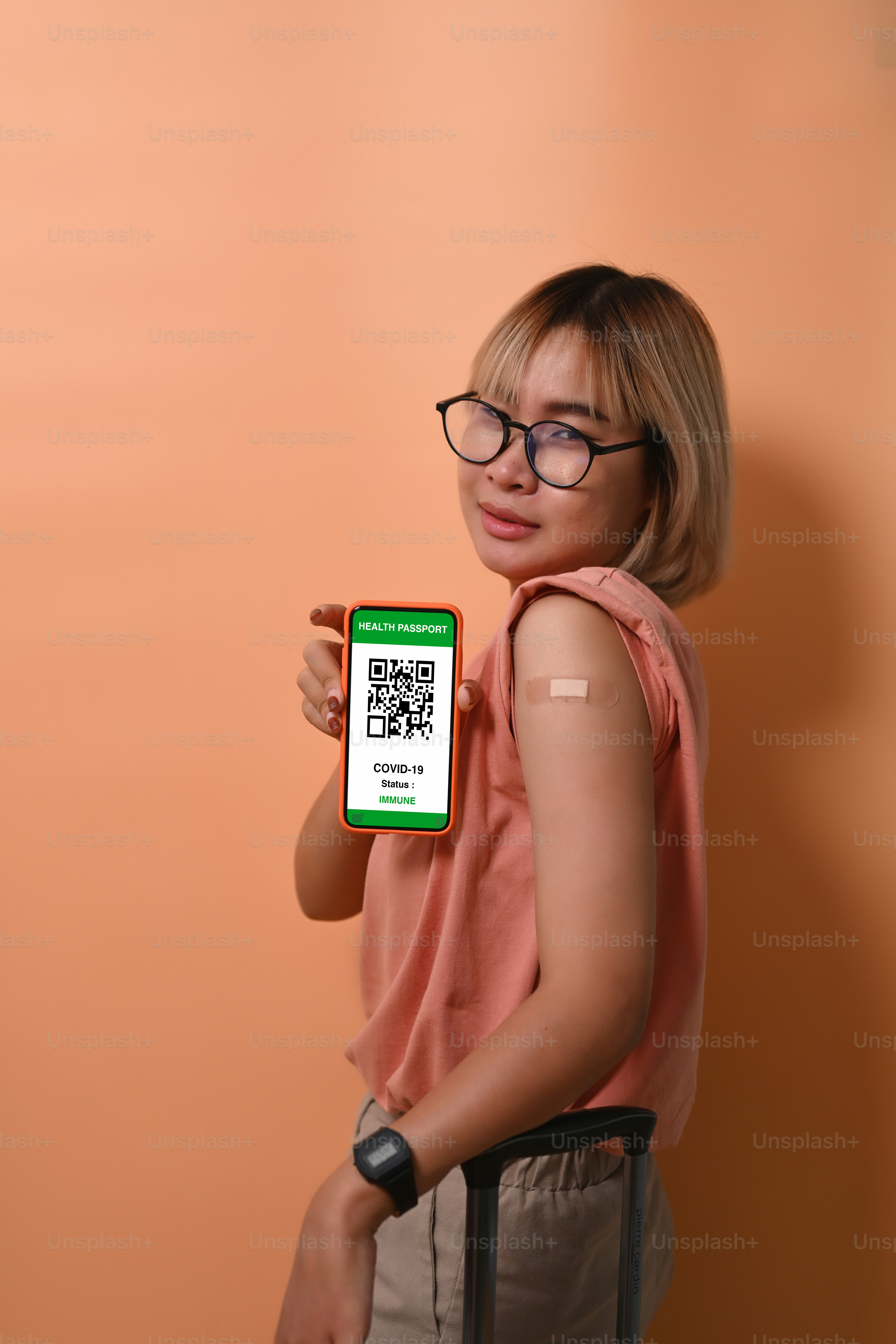 Portrait young woman showing health passport on mobile phone after receiving vaccination.