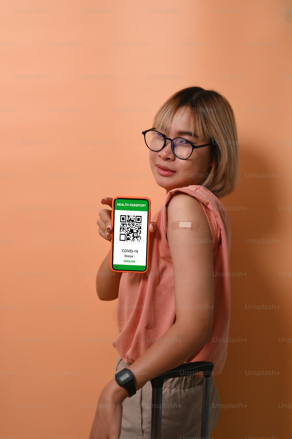 Porträt junge Frau mit Gesundheitspass auf Handy nach der Impfung.