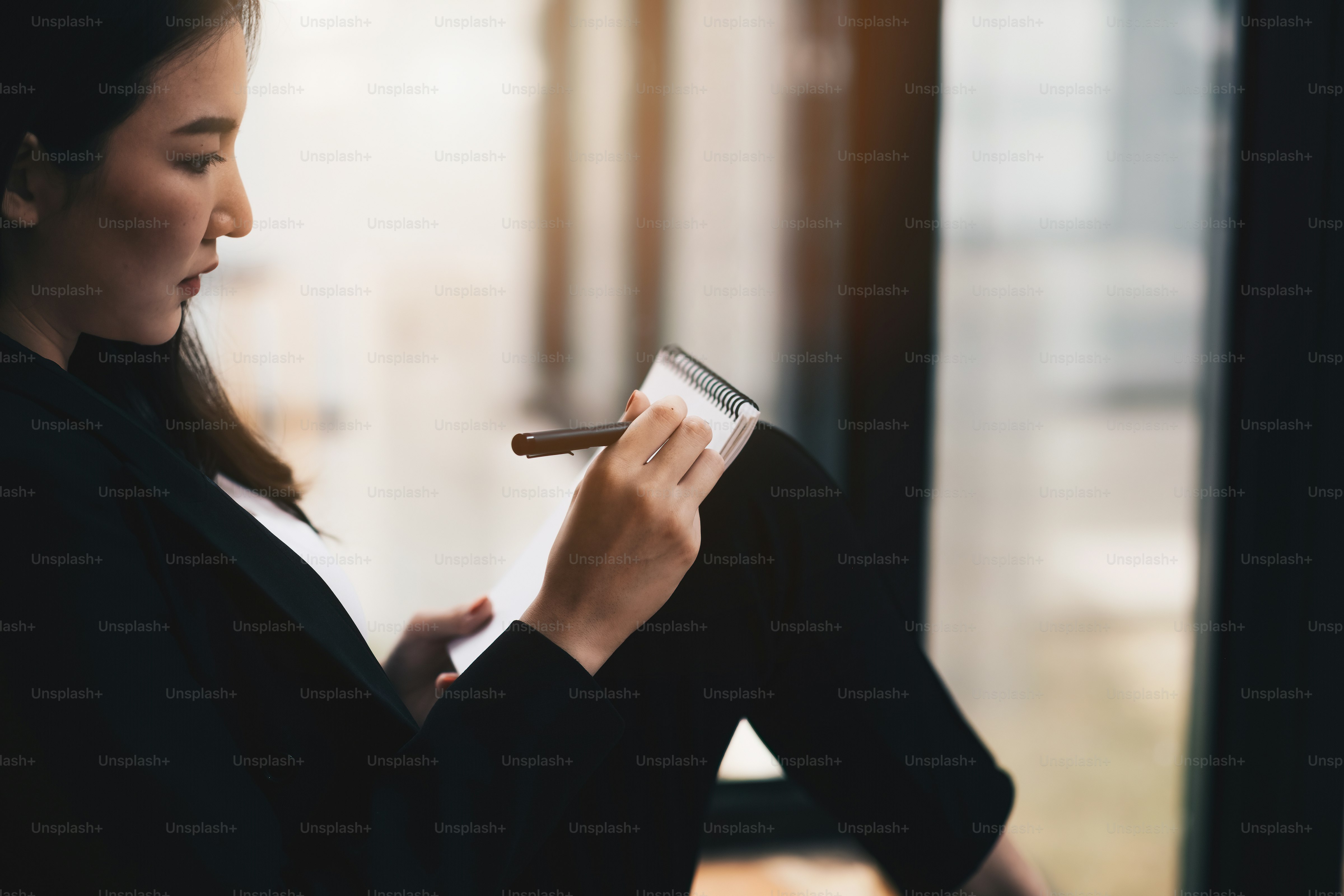 Close up asian woman hand writing on notebook at coffee cafe shop.