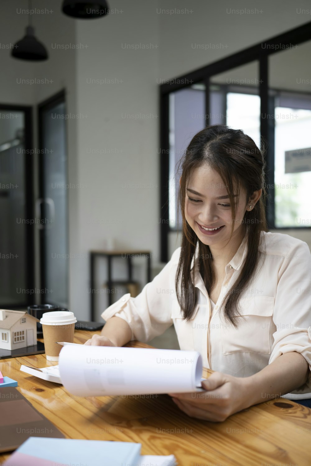 Smiling female accountant checking financial document at office.