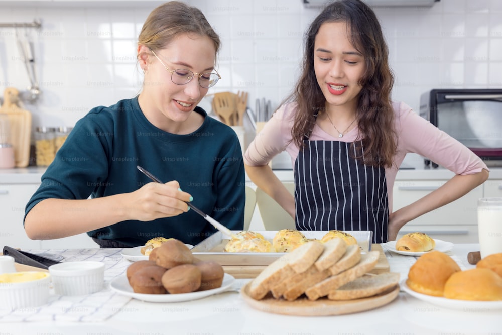 可愛い幸せな2人、お菓子を焼く美しいパン屋さん 女性たちはパン作りのレッスンで楽しい時間を過ごし、キッチンで手を使って生地を叩き、一緒にケーキを作りました。