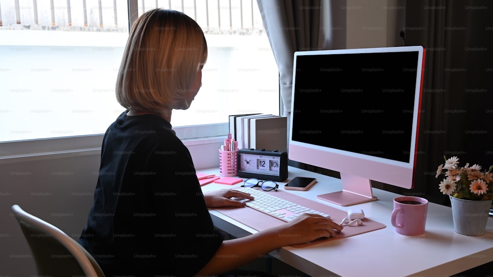 Stylish woman working with computer at modern home office.