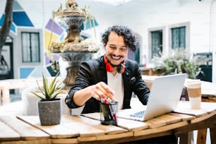 Hombre latino trabajando con computadora en una videoconferencia con auriculares en una oficina creativa en la Ciudad de México