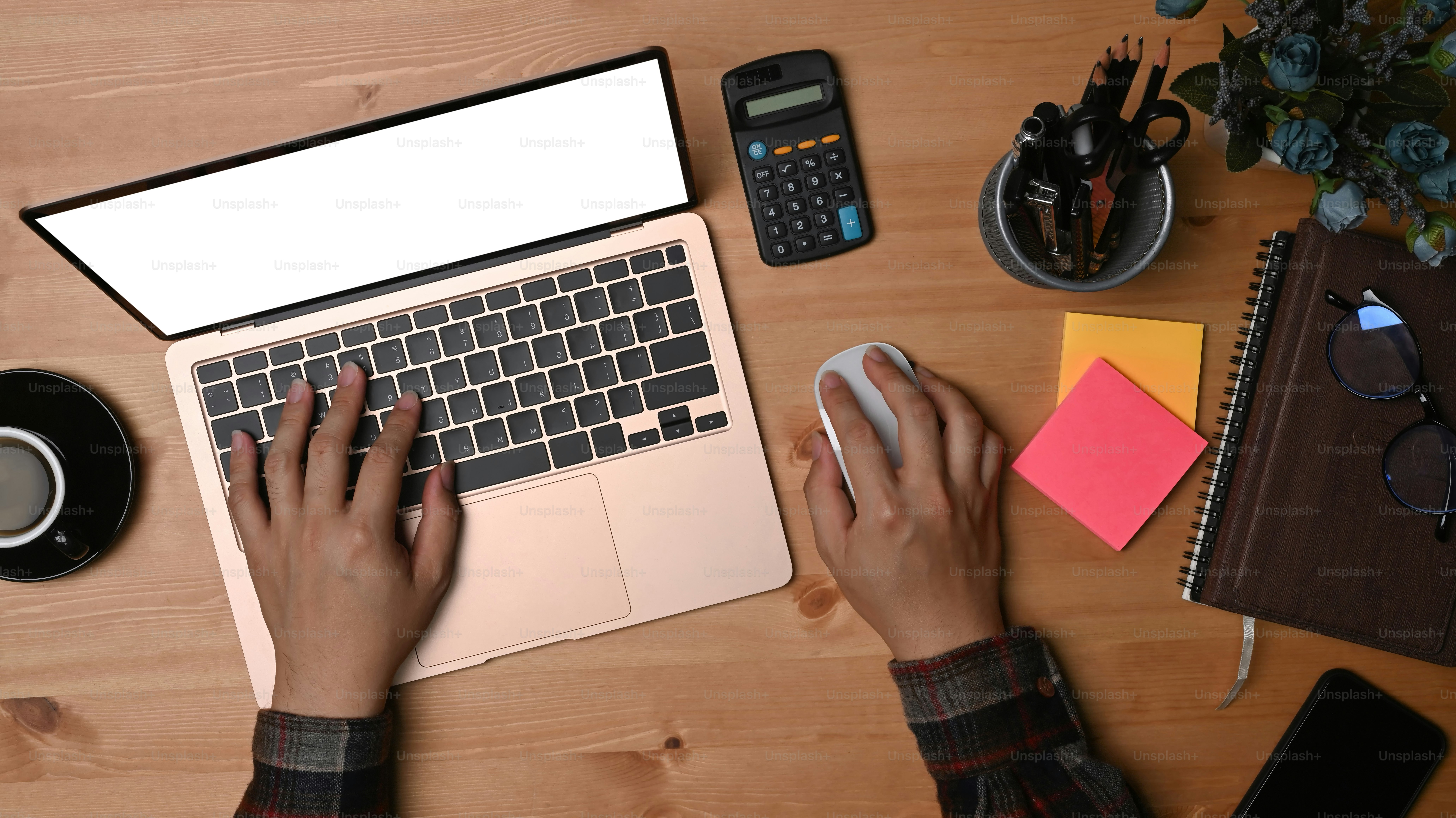 Businessman using laptop computer and calculator at his workspace.