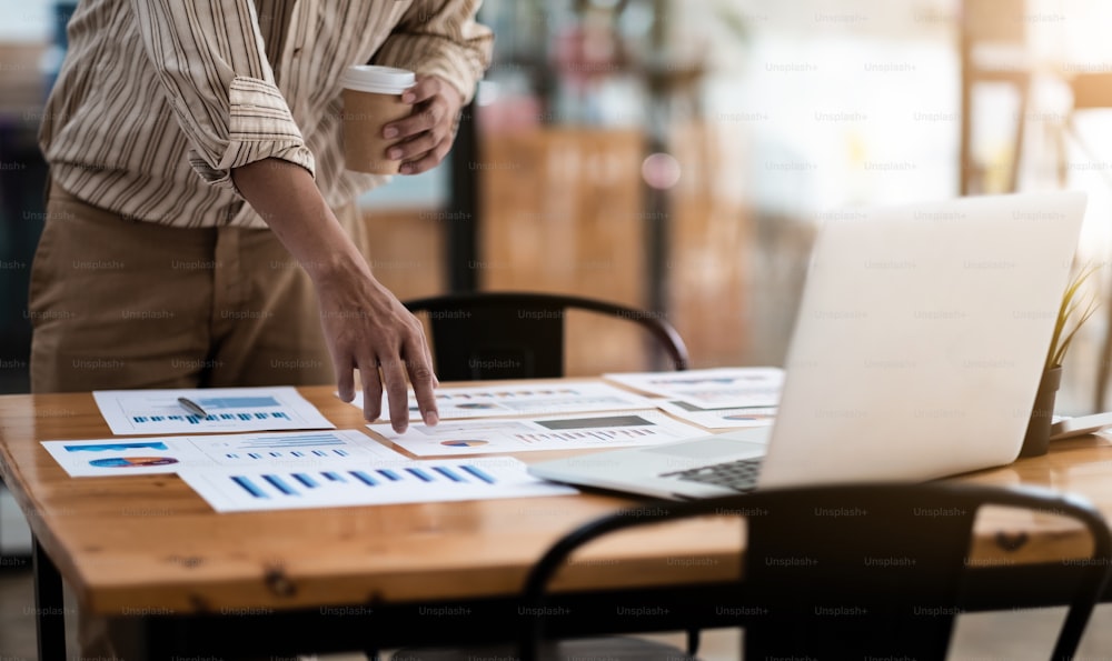 Businessman discussing analysis charts or graphs on desk table and using laptop computer.Close up male analysis and strategy concept