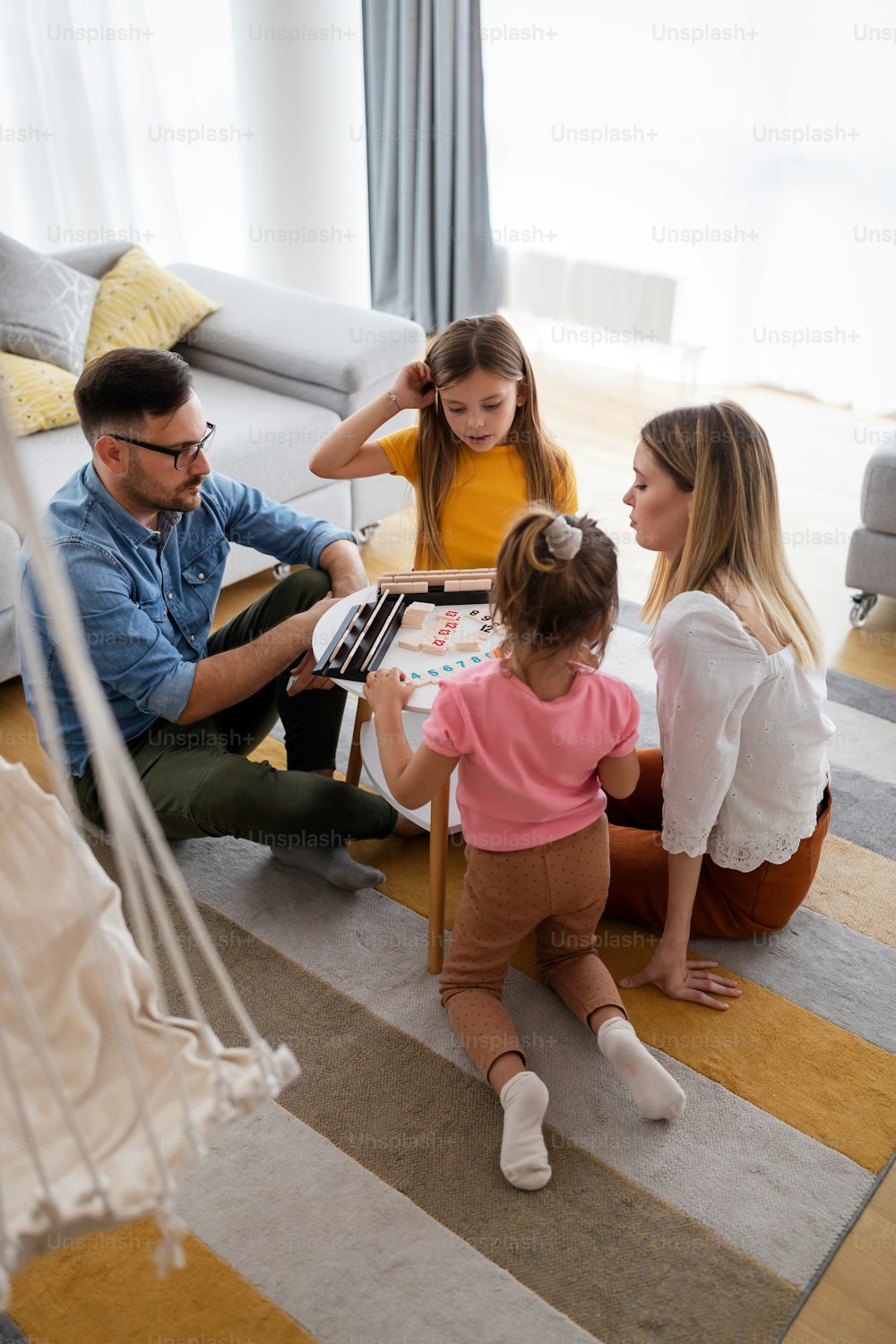 Happy parents and children having fun, playing board game at home