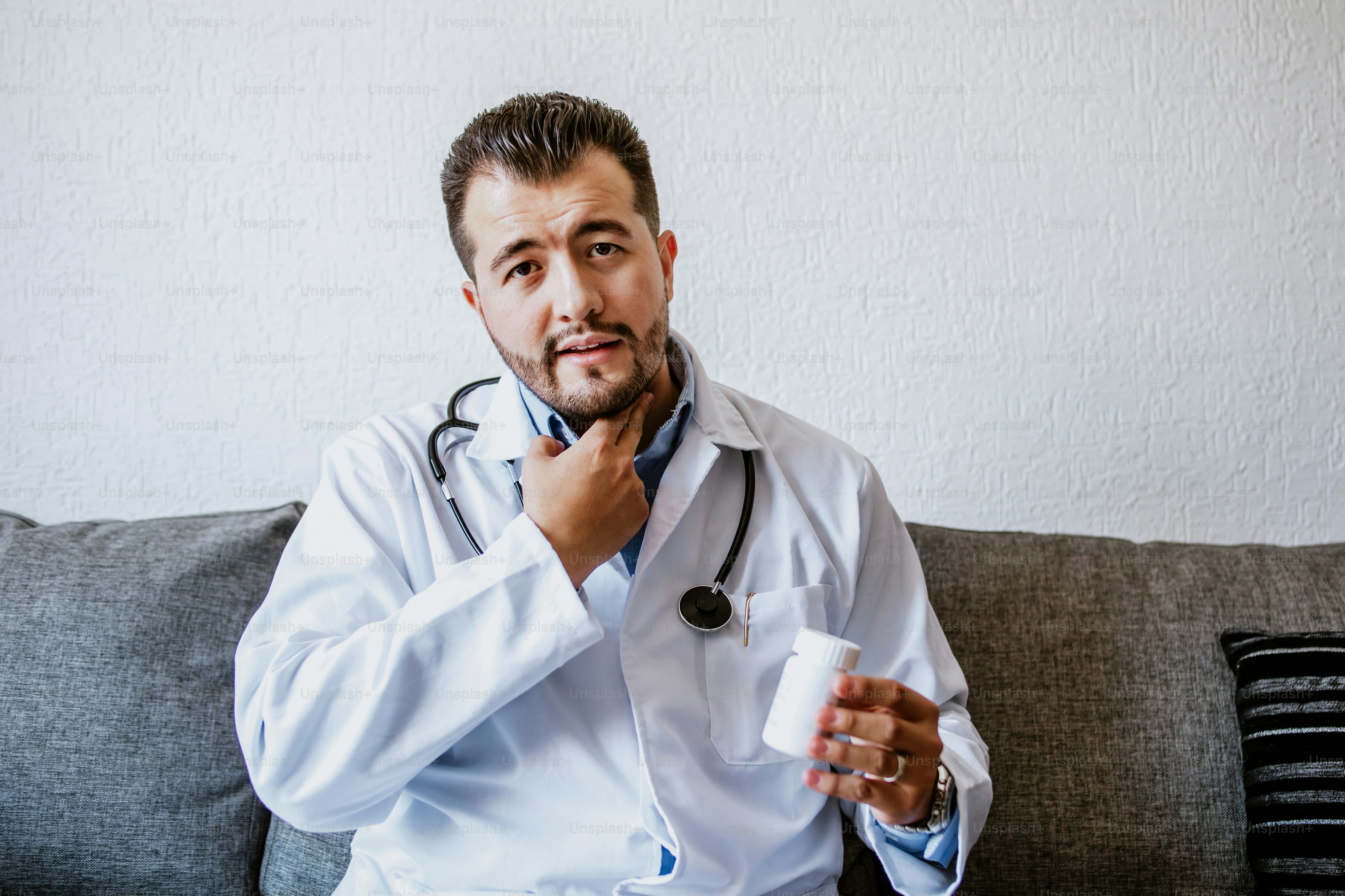 Porträt lateinischer Mann Arzt spricht online mit Patienten, macht Videoanruf, schaut in die Kamera in weißer Uniform mit Stethoskop Beratung zu Hause in Mexiko-Stadt