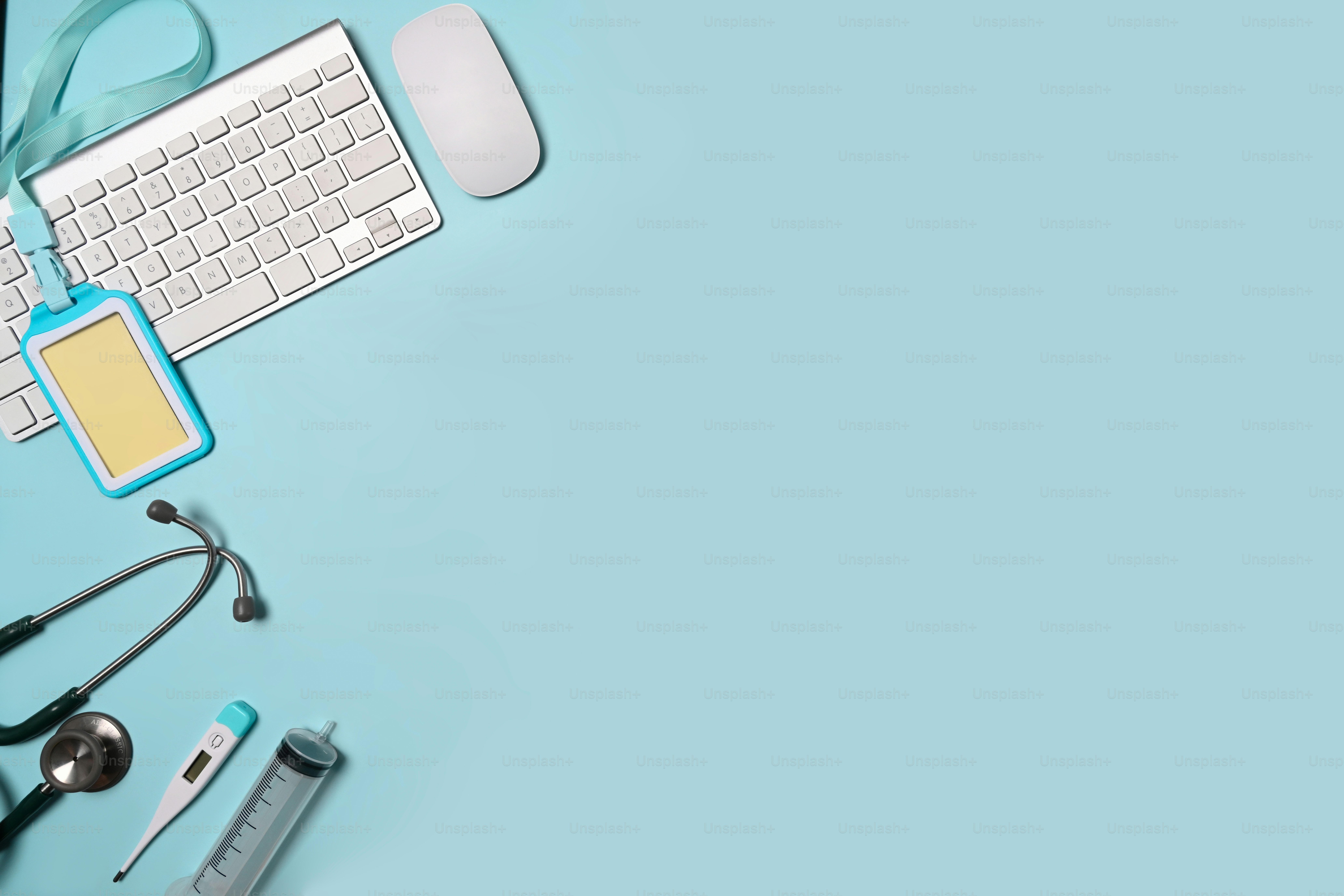 Stetoskop, keyboard, dan lencana kosong dengan latar belakang biru. Ruang kerja dokter.