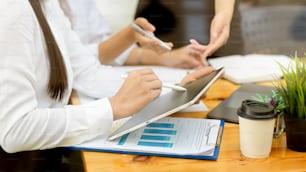 Human resources team looking at hire and laid off chart and plan to hire new worker with reports, tablet and office supplies on wood table