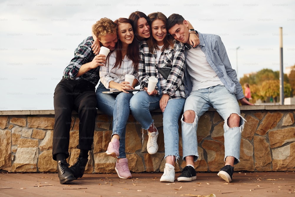 Coffee time. Group of young cheerful friends that is outdoors having fun together.