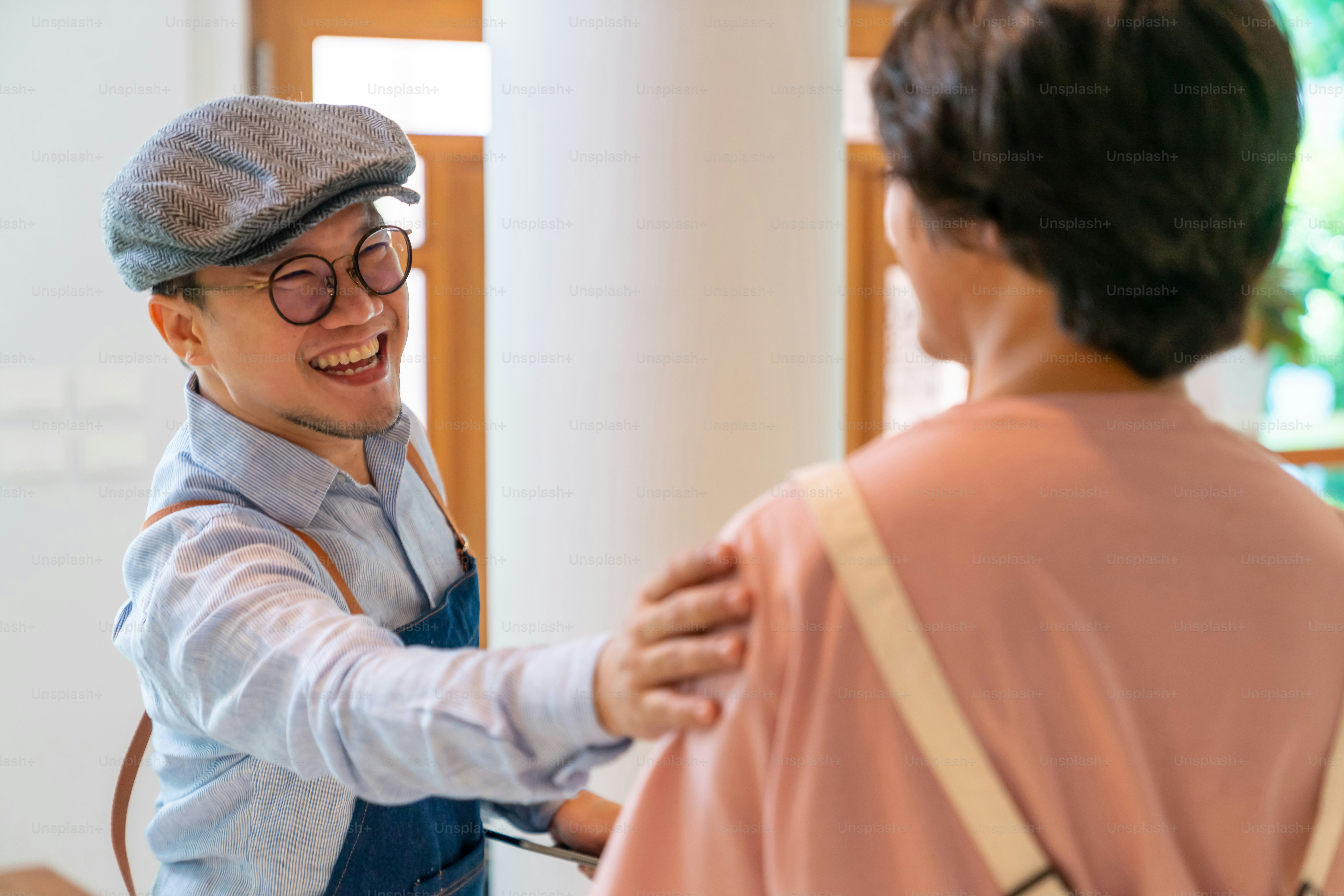 Asian male coffee shop manager briefing man and woman staff team before working. Small business cafe and restaurant owner instruct part time employee preparing service to customers before opening