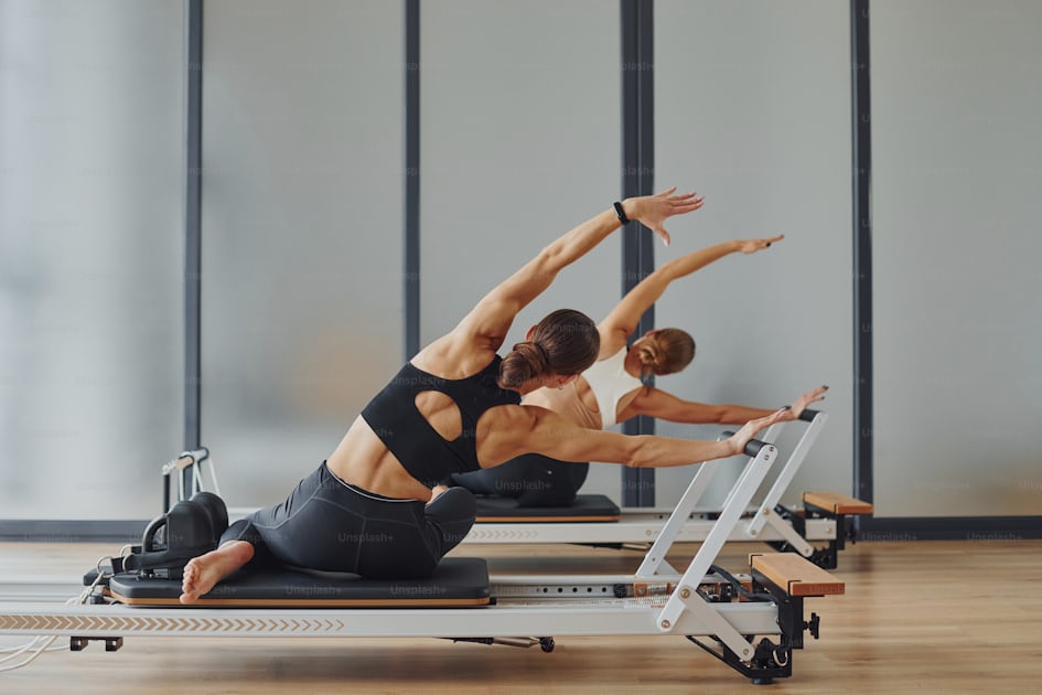 Using gym equipment. Two women in sportive wear and with slim bodies have  fitness yoga day indoors together 15347953 Stock Photo at Vecteezy