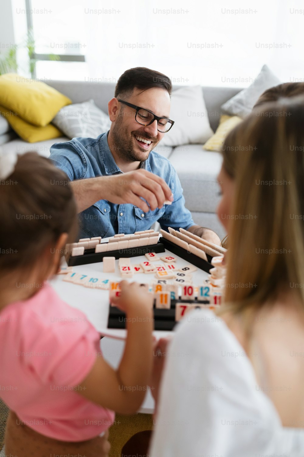 Glückliche Eltern und Kinder haben Spaß und spielen Brettspiel zu Hause
