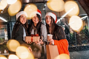 Trois femmes joyeuses passent les vacances de Noël ensemble en plein air. Conception de la nouvelle année.