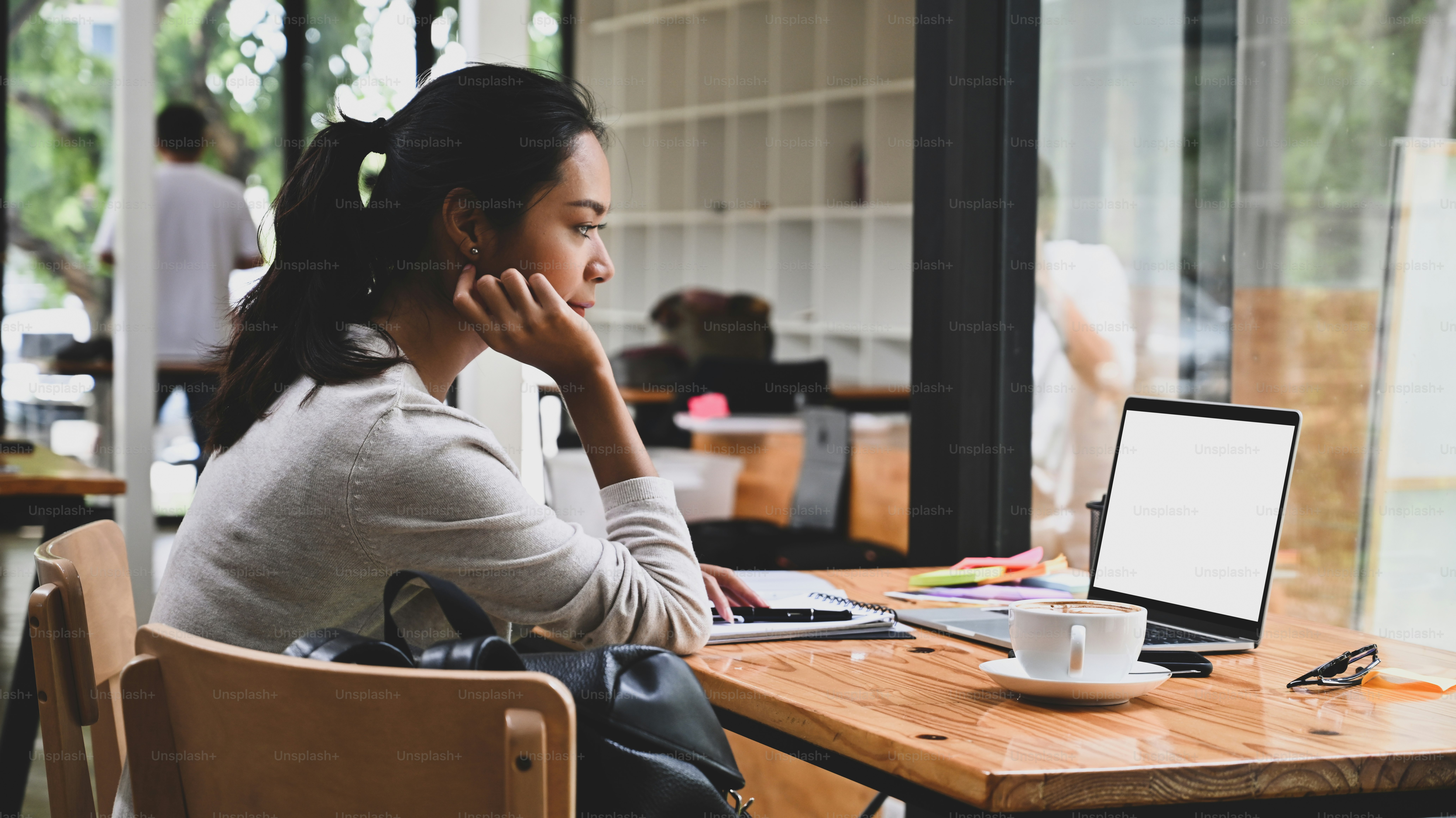 Thoughtful businesswoman checking information on laptop computer.