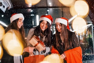 Tres alegres mujeres pasan juntas las fiestas navideñas al aire libre. Concepción del año nuevo.