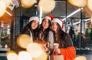 Três mulheres alegres passam as férias de Natal juntas ao ar livre. Concepção de ano novo.