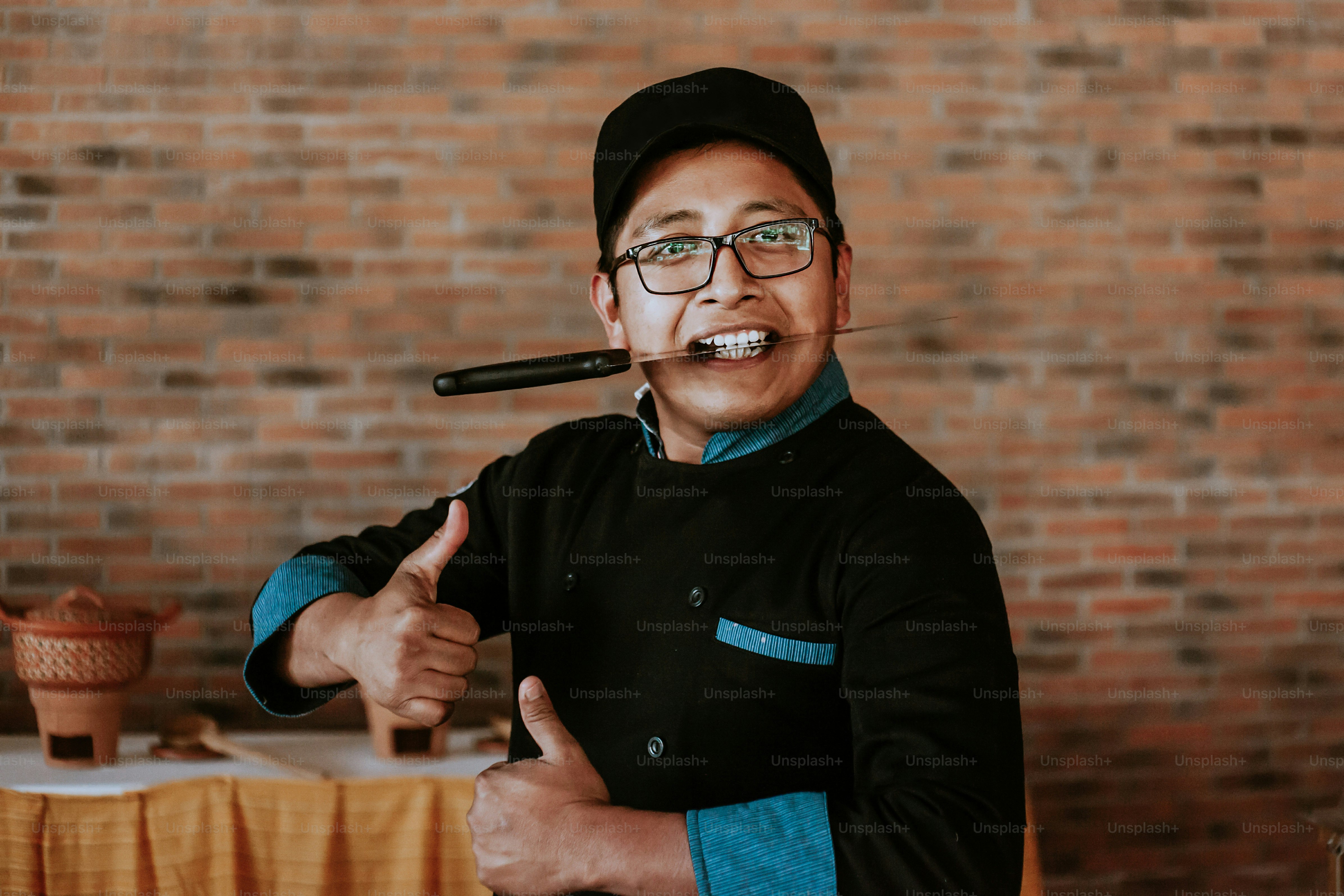 Young hispanic cook holding a knife in mexican restaurant in Mexico ...