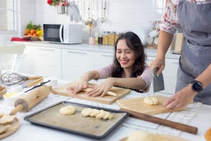 Na casa de kat, uma linda mulher sorridente e sua amiga estão fazendo pães juntos.
