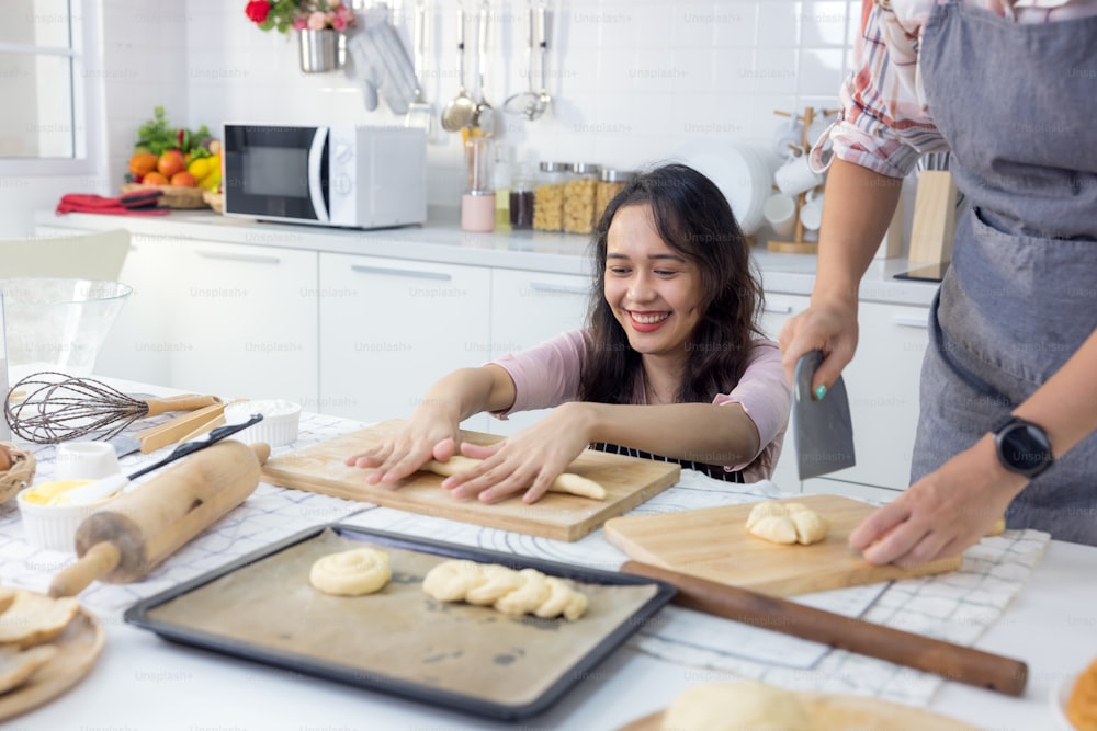 Dans la maison de Kat, une femme souriante et magnifique et son amie font du pain ensemble.