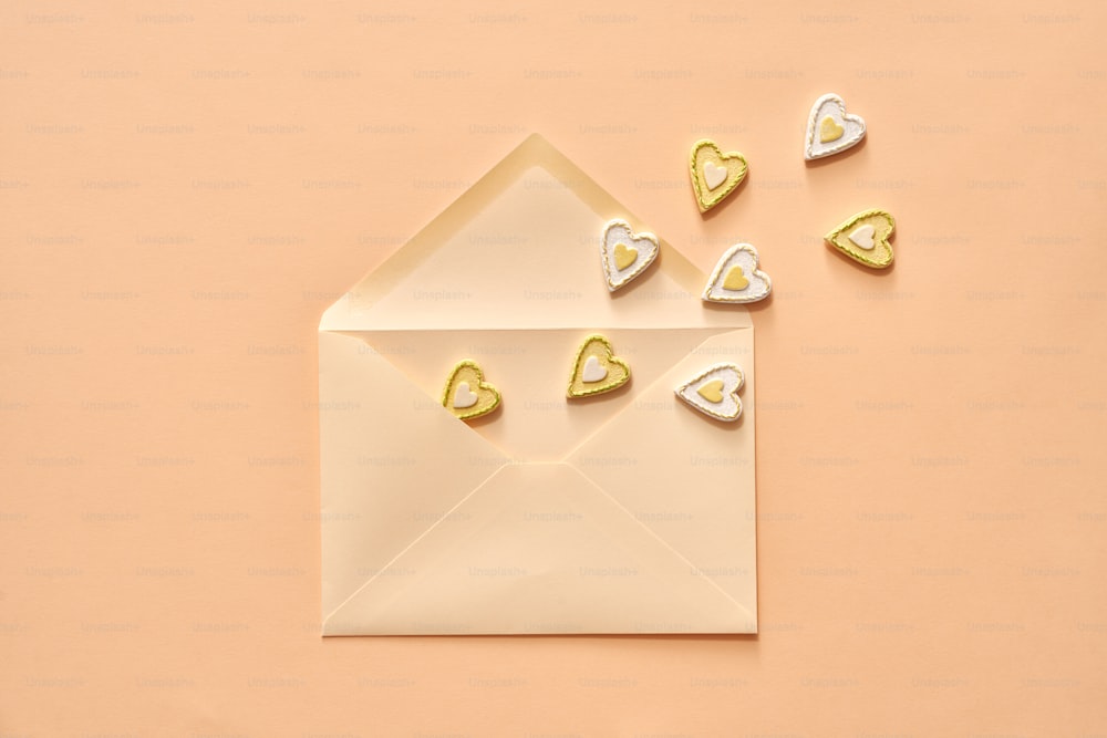 Pequenos corações voando para fora de um envelope - amor ou conceito de São Valentim no fundo pastel