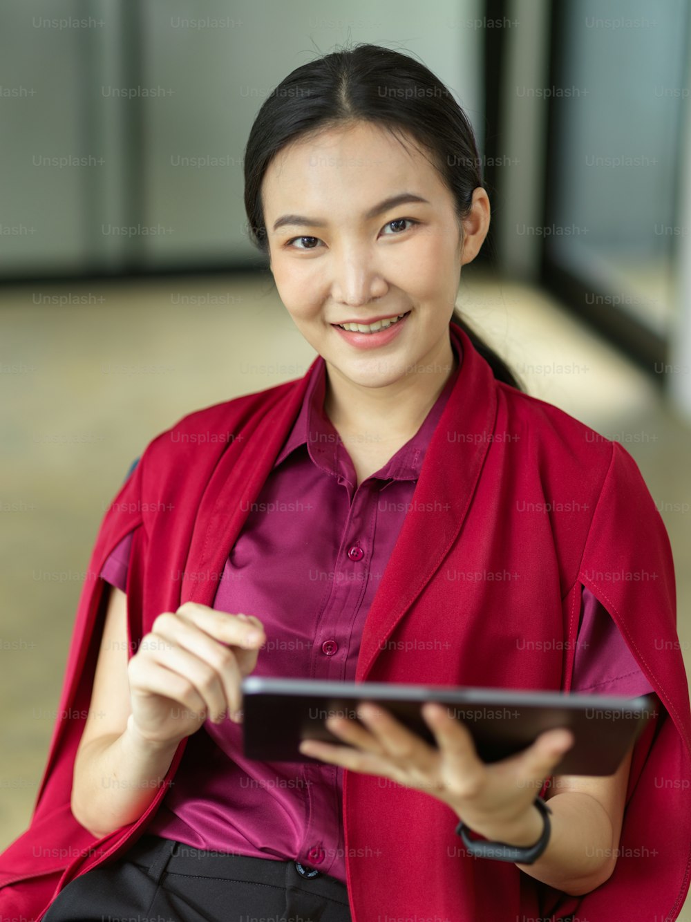 Portrait of female managing director using portable tablet to check her schedule, eyes on camera, businesswoman concept