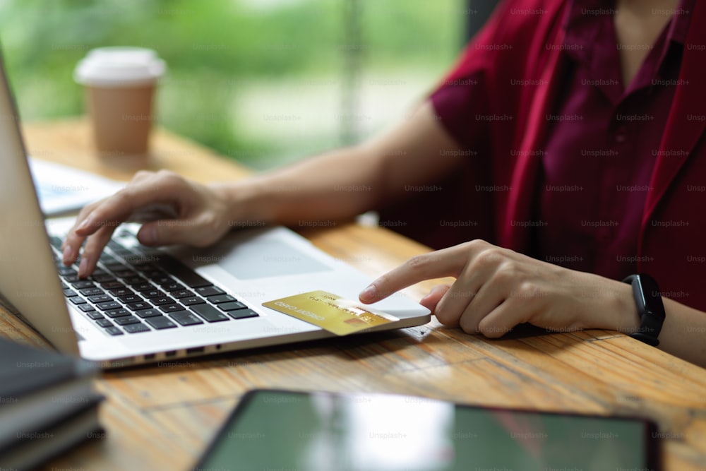 Female entering credit card number and security code via laptop for online payment, online banking