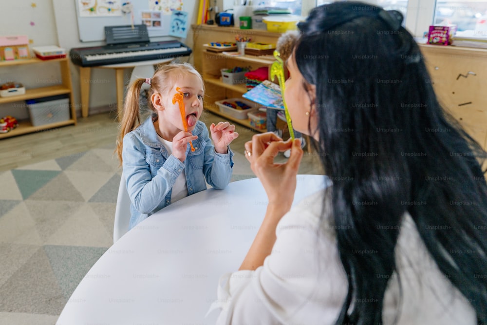 Girl on the session of speech therapist. Lesson on the development of speech in kindergarten.