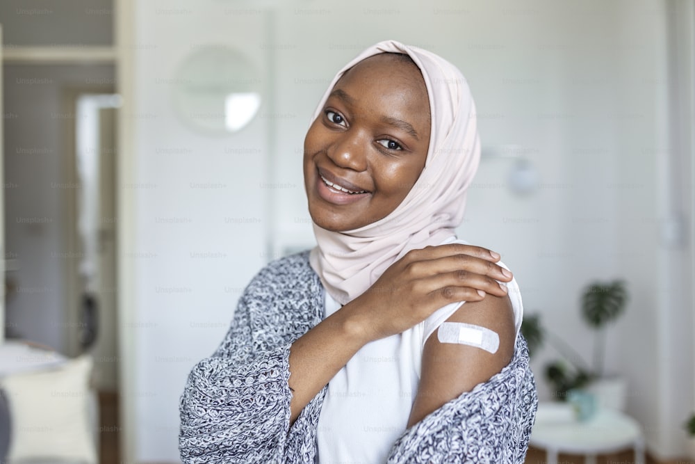 주사 백신 또는 약 후 팔에 접착 붕대,접착 붕대 석고 - 의료 장비,소프트 포커스 COVID-19 예방 접종 후 무슬림 아프리카 여성 브라키움에 접착 붕대
