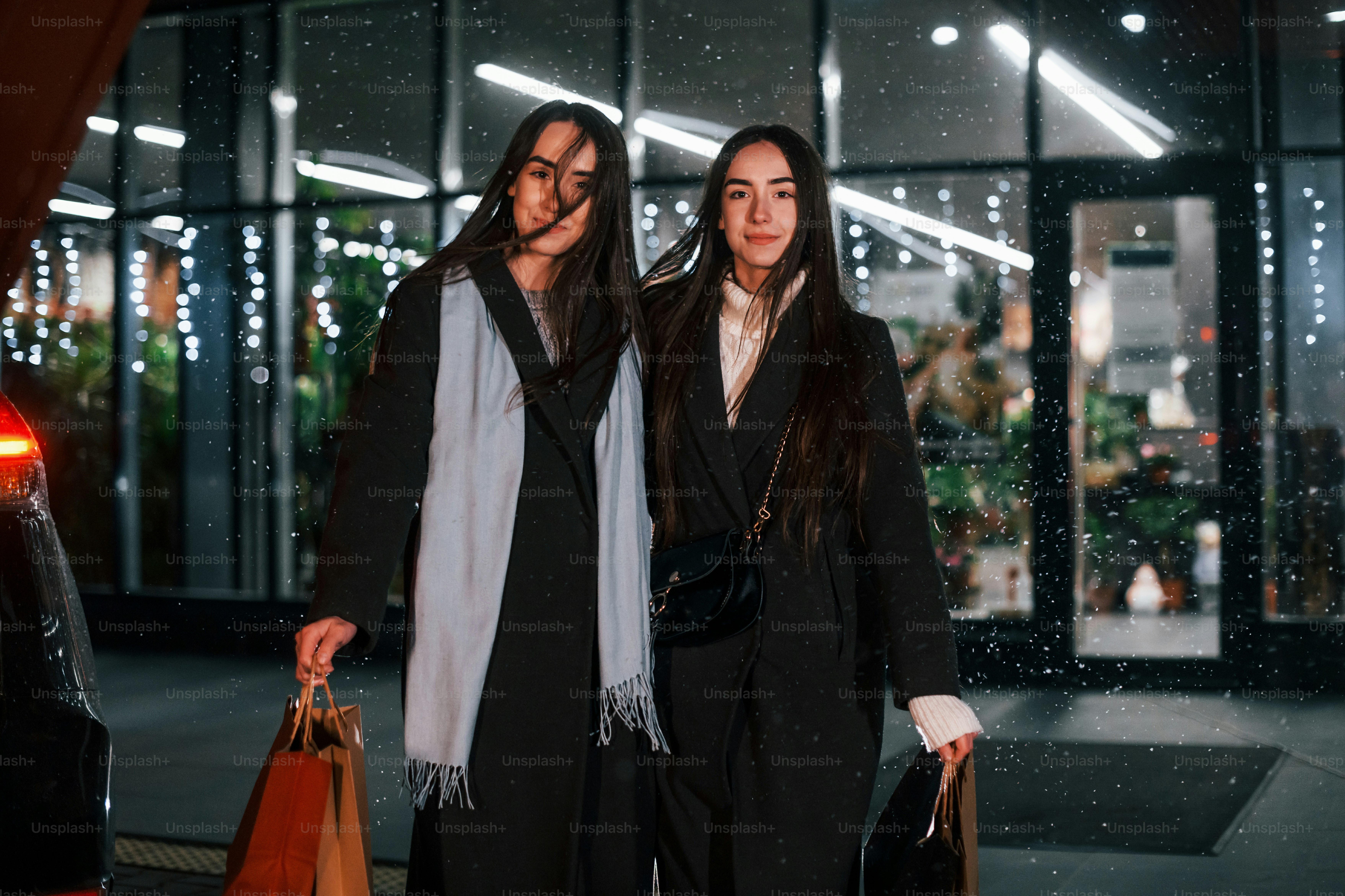 Walks with packages. Just from shopping. Happy sisters twins spends Christmas holidays together outdoors. Conception of new year.