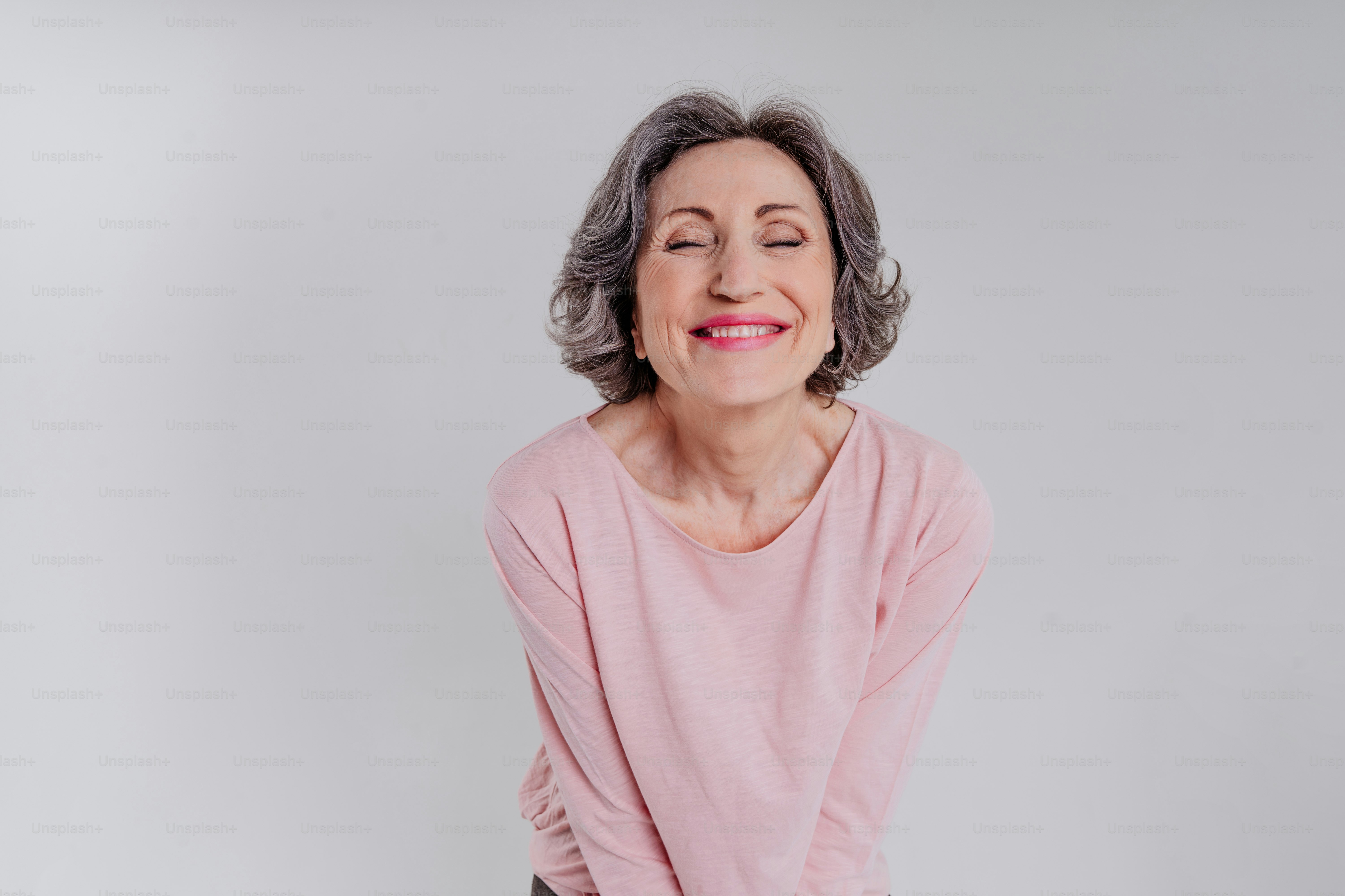 Retrato de una mujer madura feliz y elegante sobre fondo gris claro con espacio en blanco para texto
