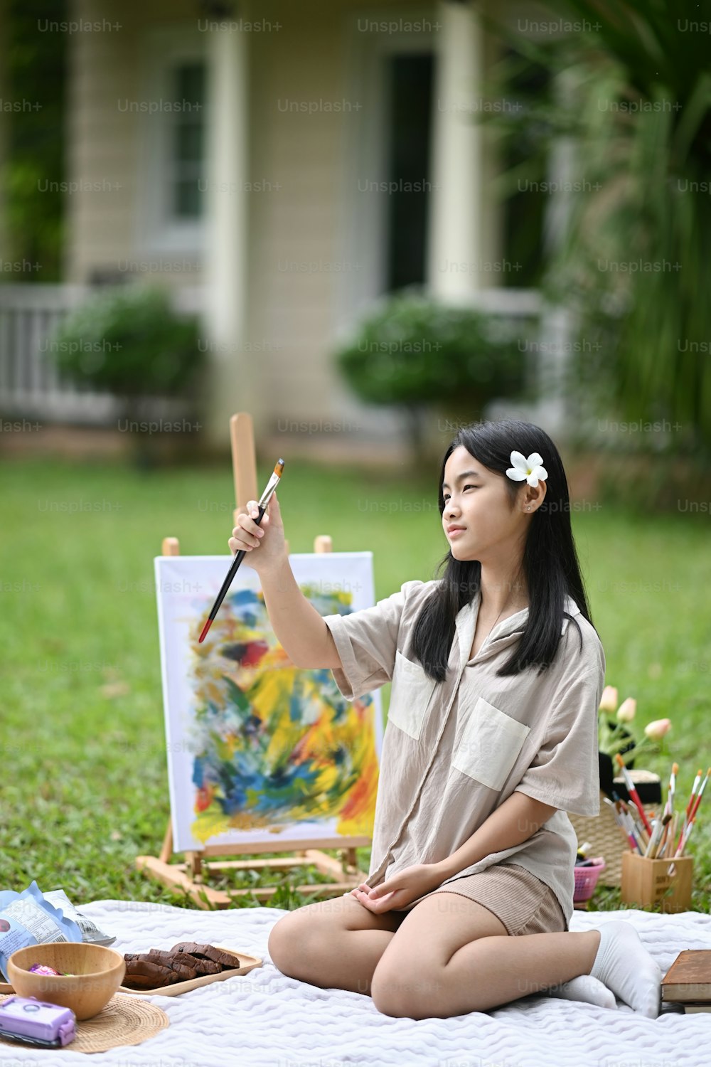 屋外で水彩画で絵を描いたアジアの女の子の肖像画。