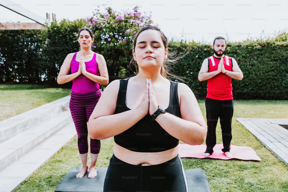 Group of young latin people meditating with closed eyes in the garden in Latin America