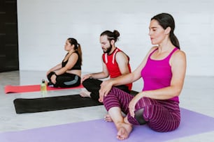 Group of young latin people meditating quiet in yoga studio in Latin America