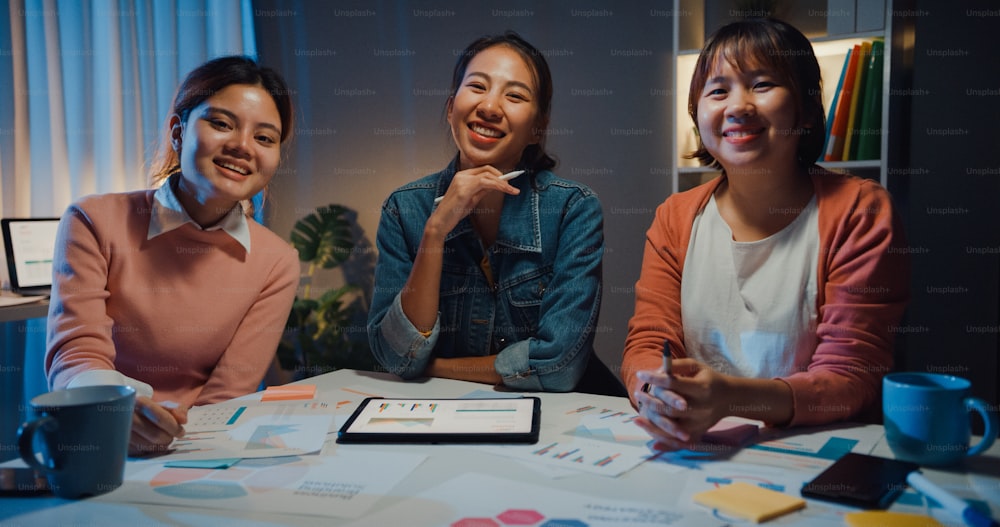 Millennial Asia people meeting brainstorming ideas about new paperwork project colleagues working together plan success strategy enjoy teamwork in small modern night office. Coworker teamwork concept.