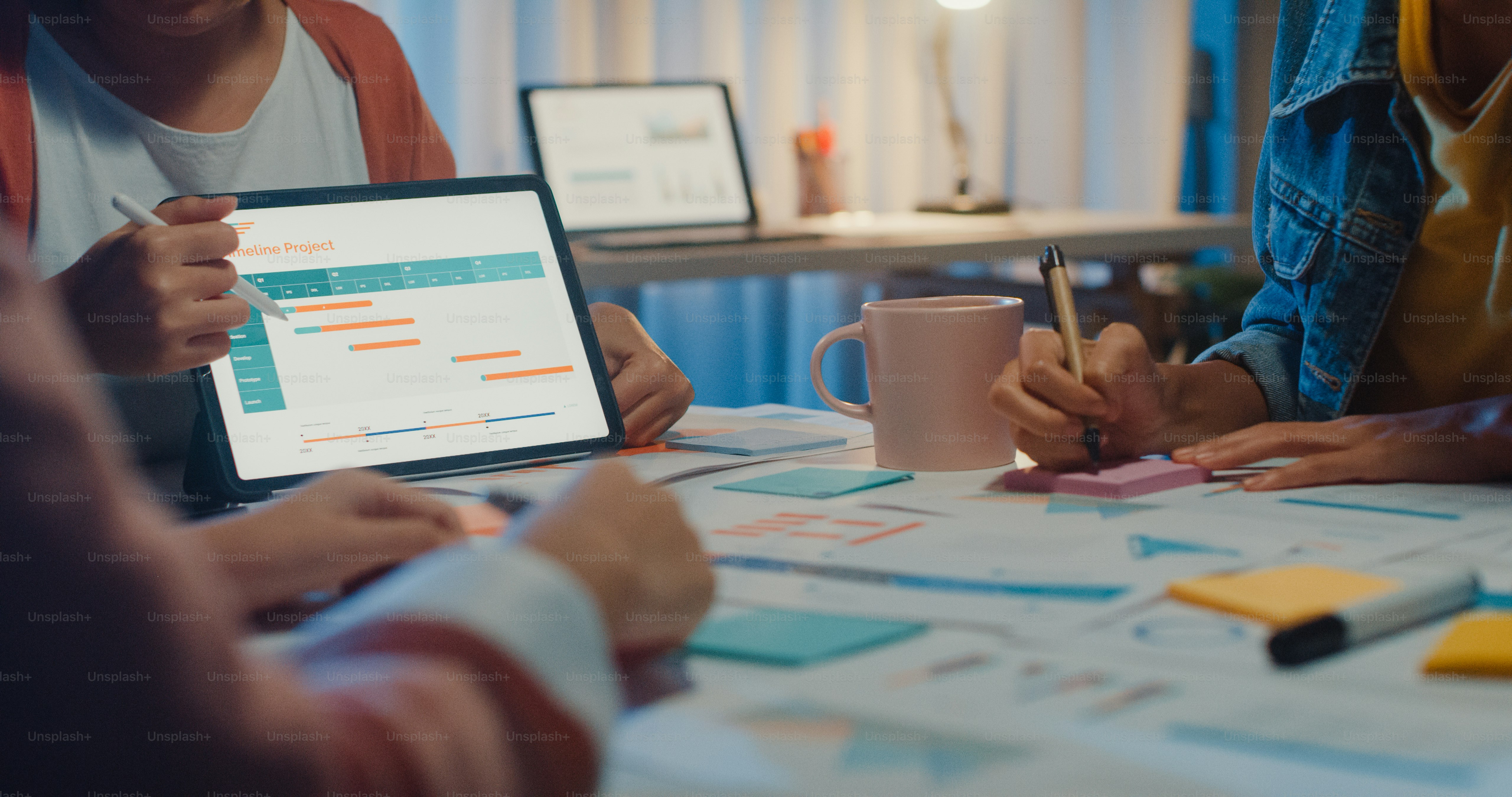 Close-up asia businesspeople meeting plan analysis statistics brainstorm and header of team hold tablet point graph chart and employee take note at home office night. Finance strategy success concept.