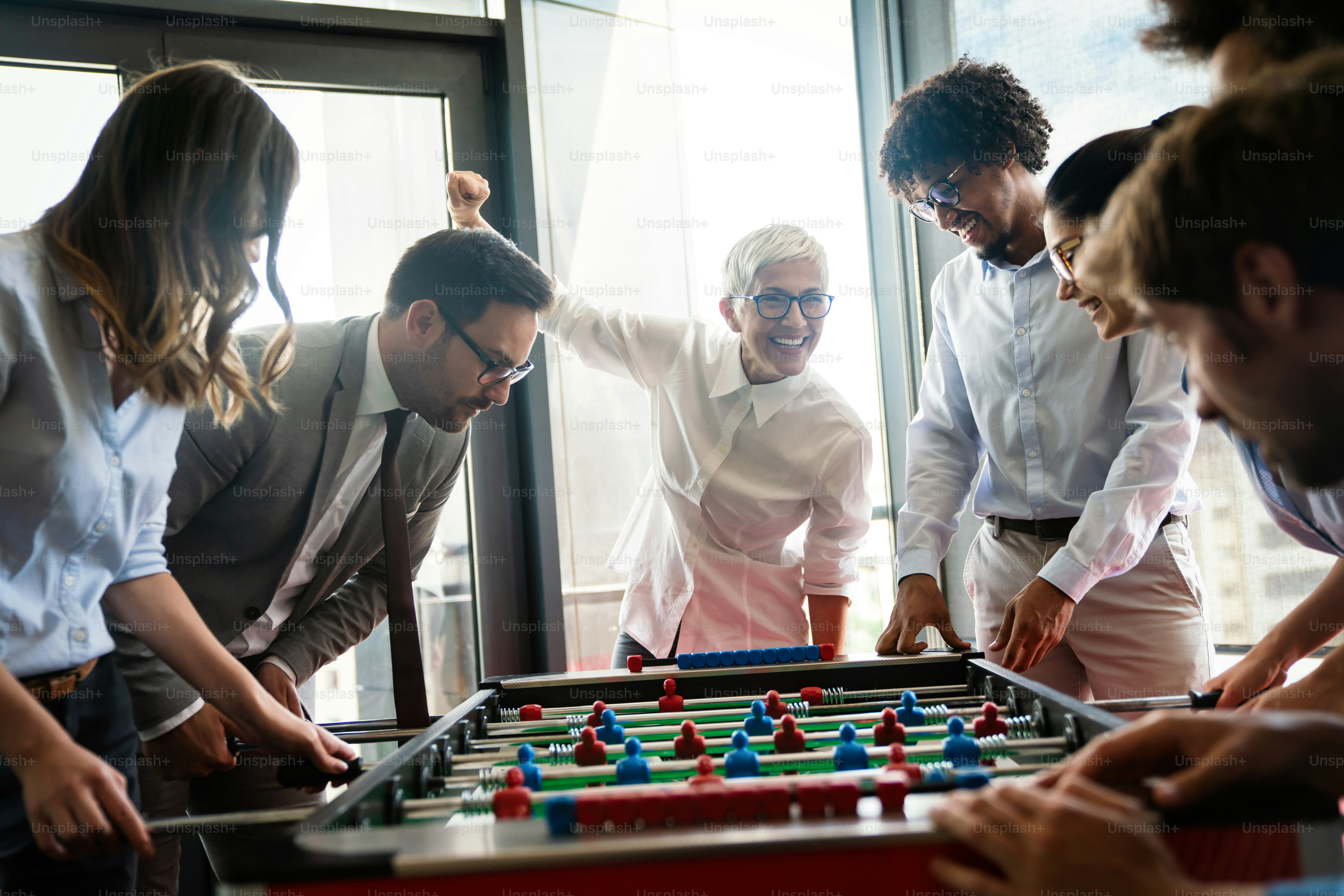 Funcionários jogando futebol de mesa no escritório durante o intervalo para aliviar o estresse do trabalho