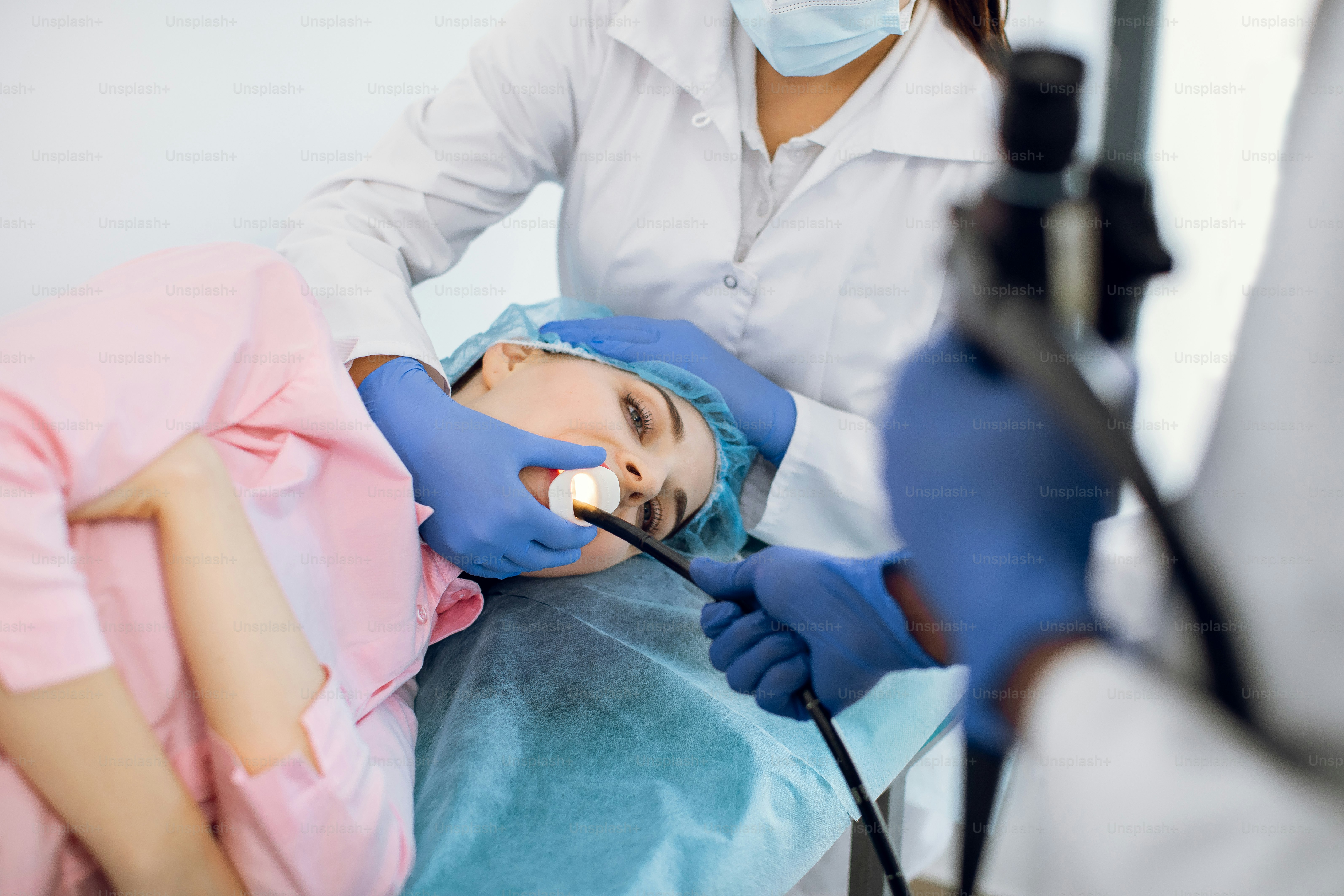 Young woman patient lying on the couch in modern clinic, having gastroscopic examination of the stomach and digestive tract