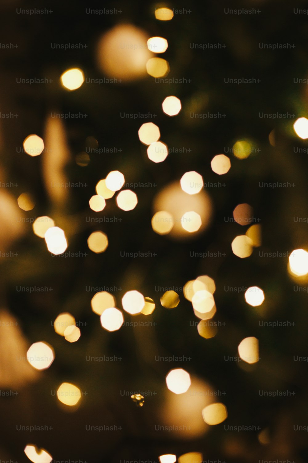 Luci di Natale dorate bokeh. Sfondo natalizio, illuminazione incandescente sull'albero di Natale decorato sfocato nella stanza festiva serale. Atmosferico. Buon Natale e Buone Feste