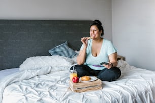 Joven latina desayunando en su habitación en América Latina