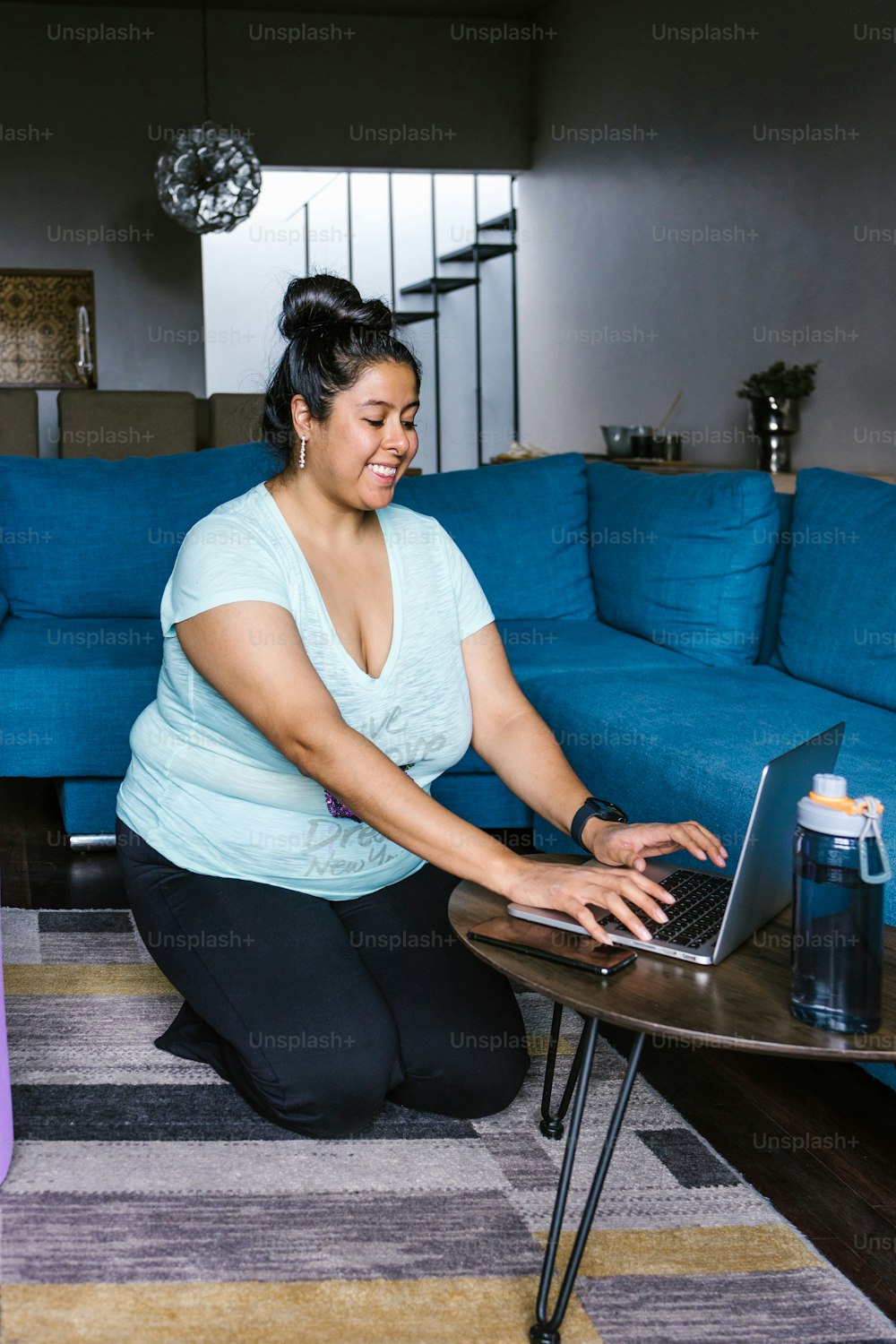 Curvy hispanic girl kneeling in living room using computer in Latin America, plus size woman